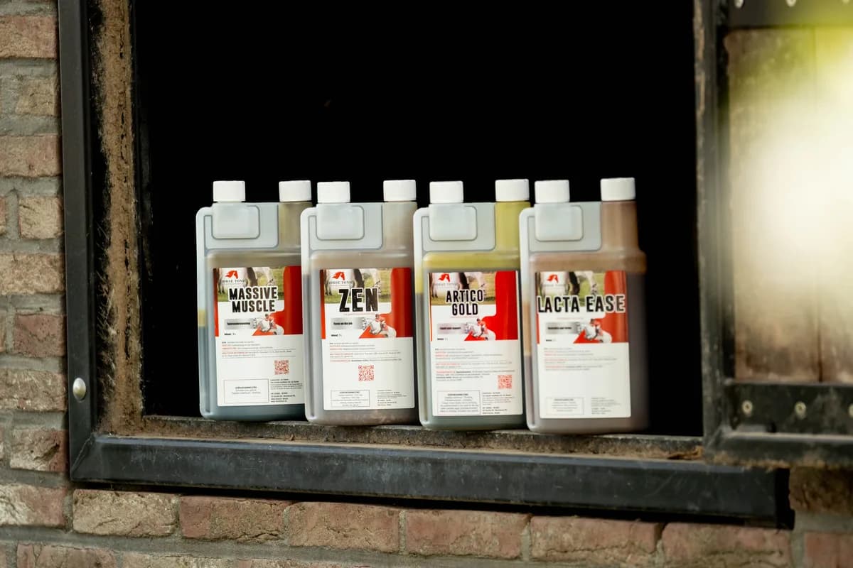 De vier Horse Tonic flessen op een vensterbank in de stal